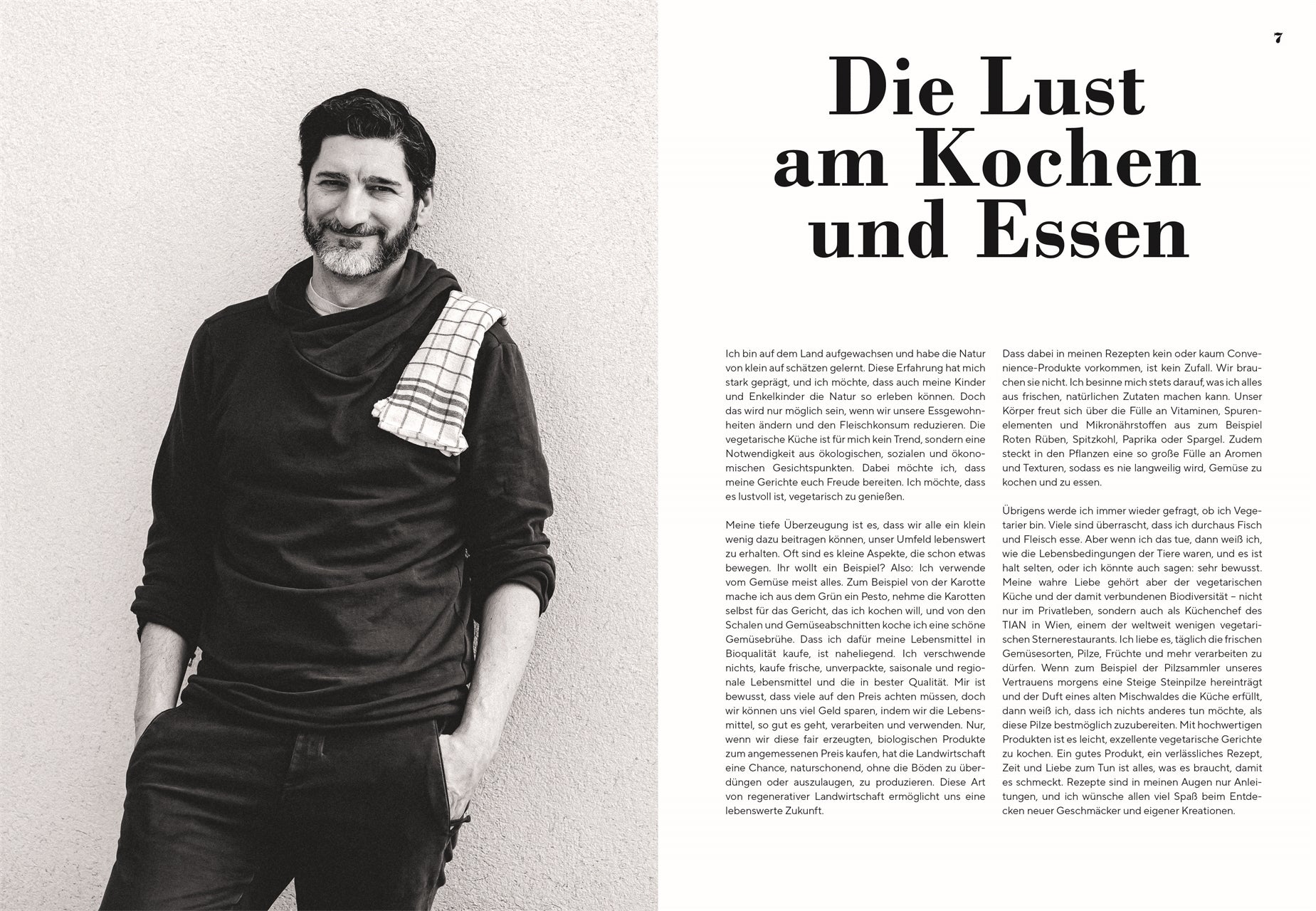 Portrait Paul Ivić: Schwarz-weißes Portrait des Kochs Paul Ivić mit Bart, lächelnd, in dunkler Kleidung und kariertem Küchentuch über der Schulter, vor hellem Hintergrund.