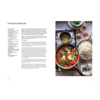 Ei-Sambal-Shakshuka: Rote Shakshuka in einer Pfanne mit pochierten Eiern, serviert mit Reis, frischen Kräutern und weiteren Zutaten wie Eiern und zerstoßenen Gewürzen auf einer Küchenarbeitsfläche.