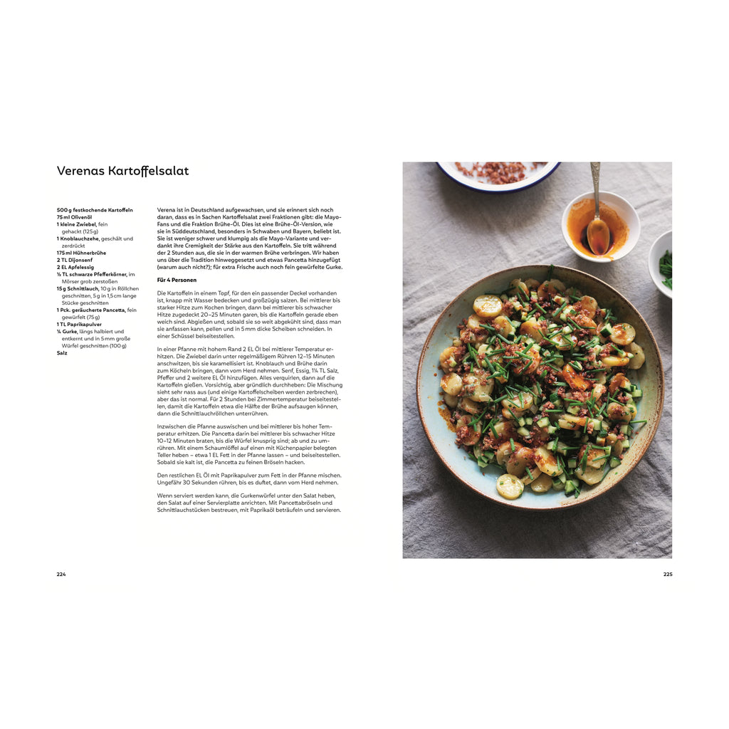 Verenas Kartoffelsalat: Schüssel mit traditionellem Brüh-Kartoffelsalat mit Gurkenstücken, Schnittlauch, Speck und Paprikaöl, daneben Schälchen mit Dressingzutaten und Kräutern.