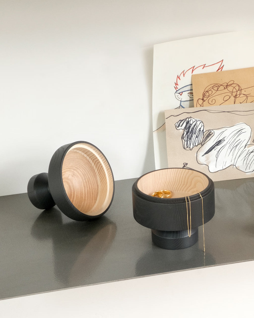 Designobjekte DEVAKI von NIEVEN auf Regal in Schwarz handgedrechselte Holzschalen aus Esche moderne Wohnaccessoires zur Aufbewahrung und Dekoration hergestellt in Deutschland.