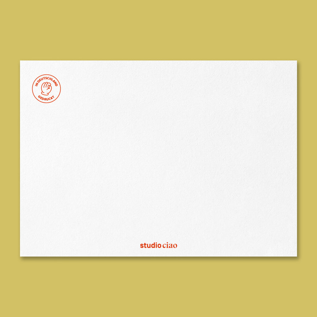 Rückseite der Geburtstagskarte mit strukturierter weißer Papieroberfläche, rotem Siegel ‚In Deutschland gedruckt‘ oben links und kleinem Schriftzug ‚studio ciao‘ unten mittig“