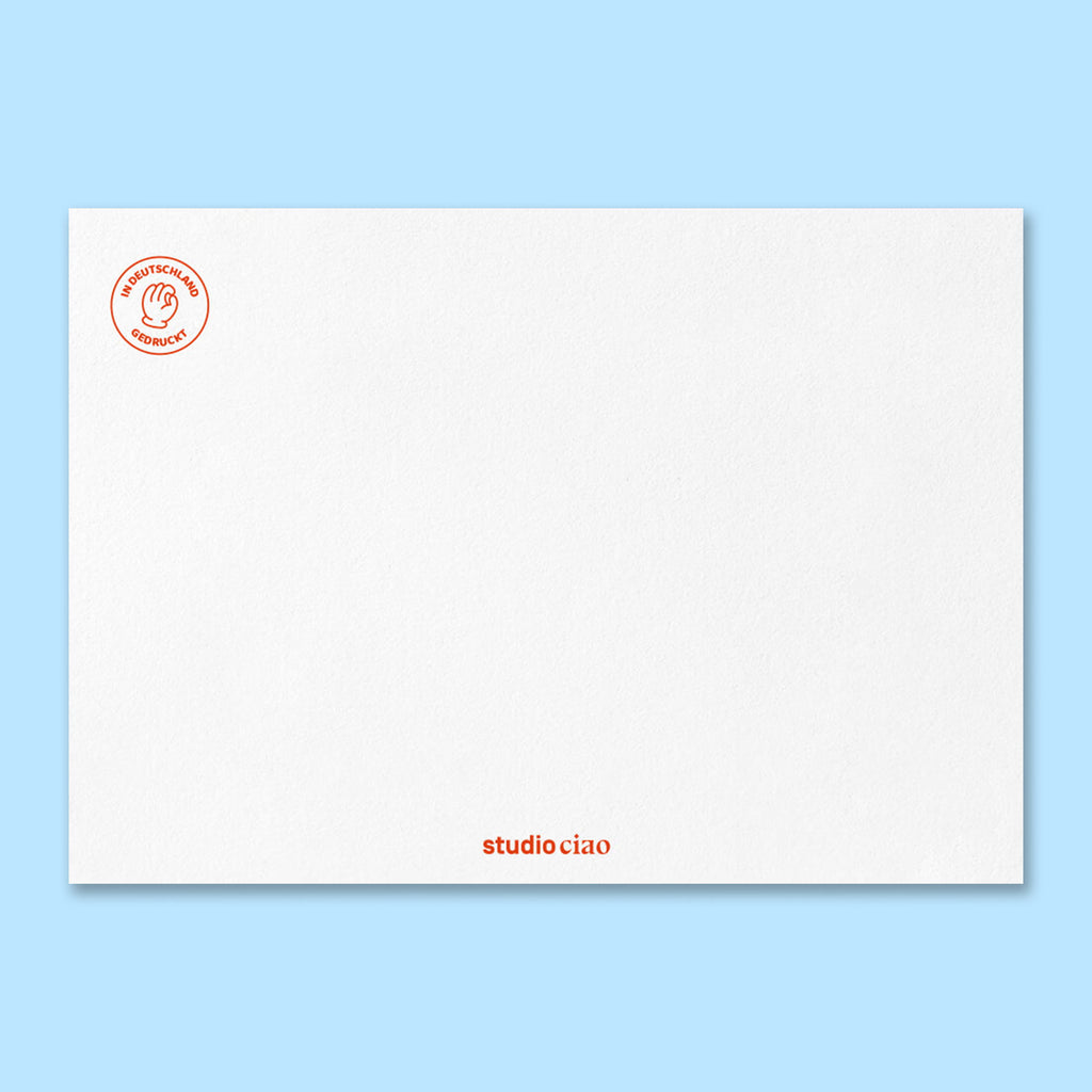 Rückseite der Geburtstagskarte mit strukturierter weißer Papieroberfläche, rotem Siegel ‚In Deutschland gedruckt‘ oben links und kleinem Schriftzug ‚studio ciao‘ unten mittig.