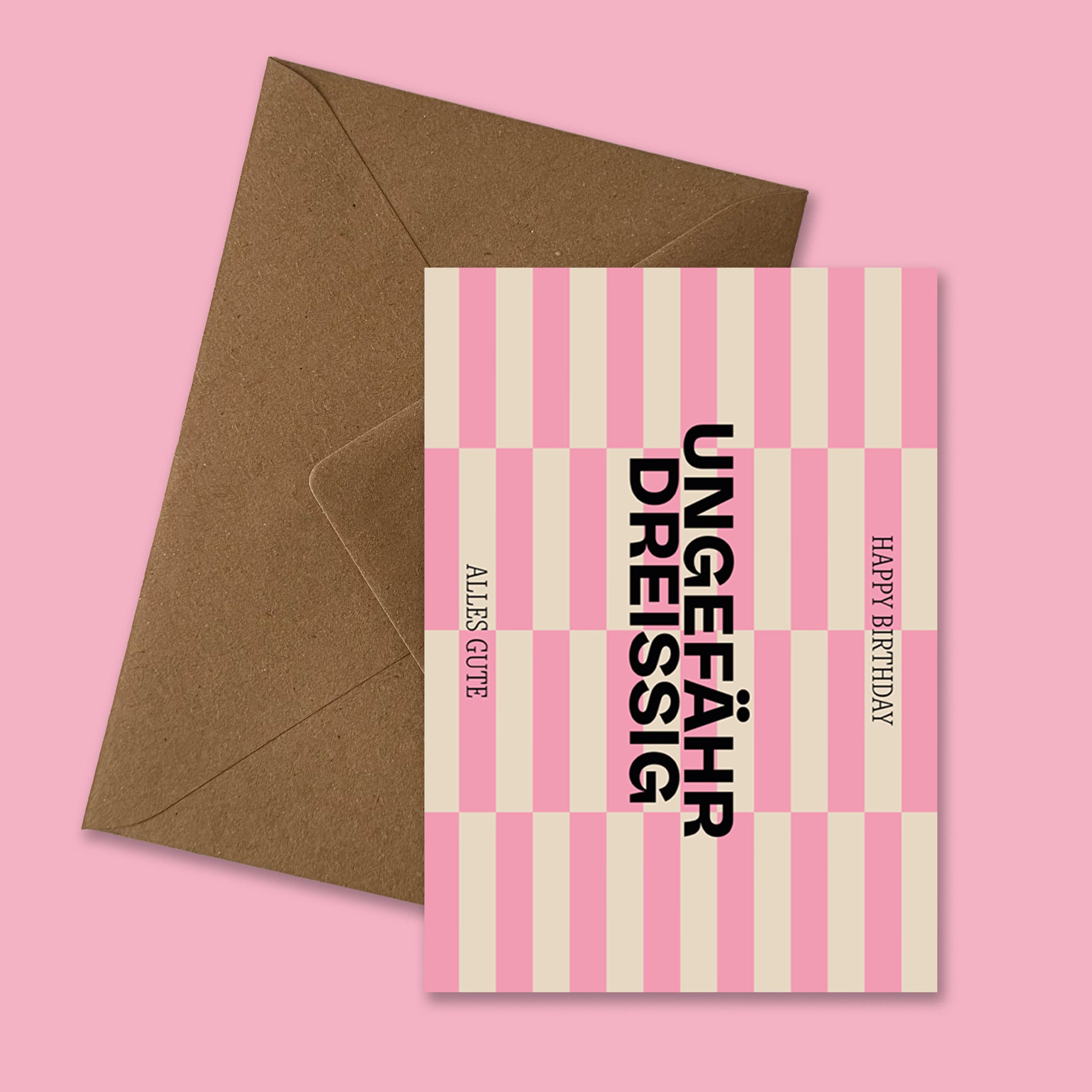 Moderne Geburtstagskarte ‚Ungefähr Dreissig‘ mit grafischem Streifenmuster in Pink und Beige, schwarzer Typografie und Aufschrift ‚Happy Birthday‘ und ‚Alles Gute‘, präsentiert mit braunem recyceltem Kraftpapier-Umschlag produziert in Deutschland