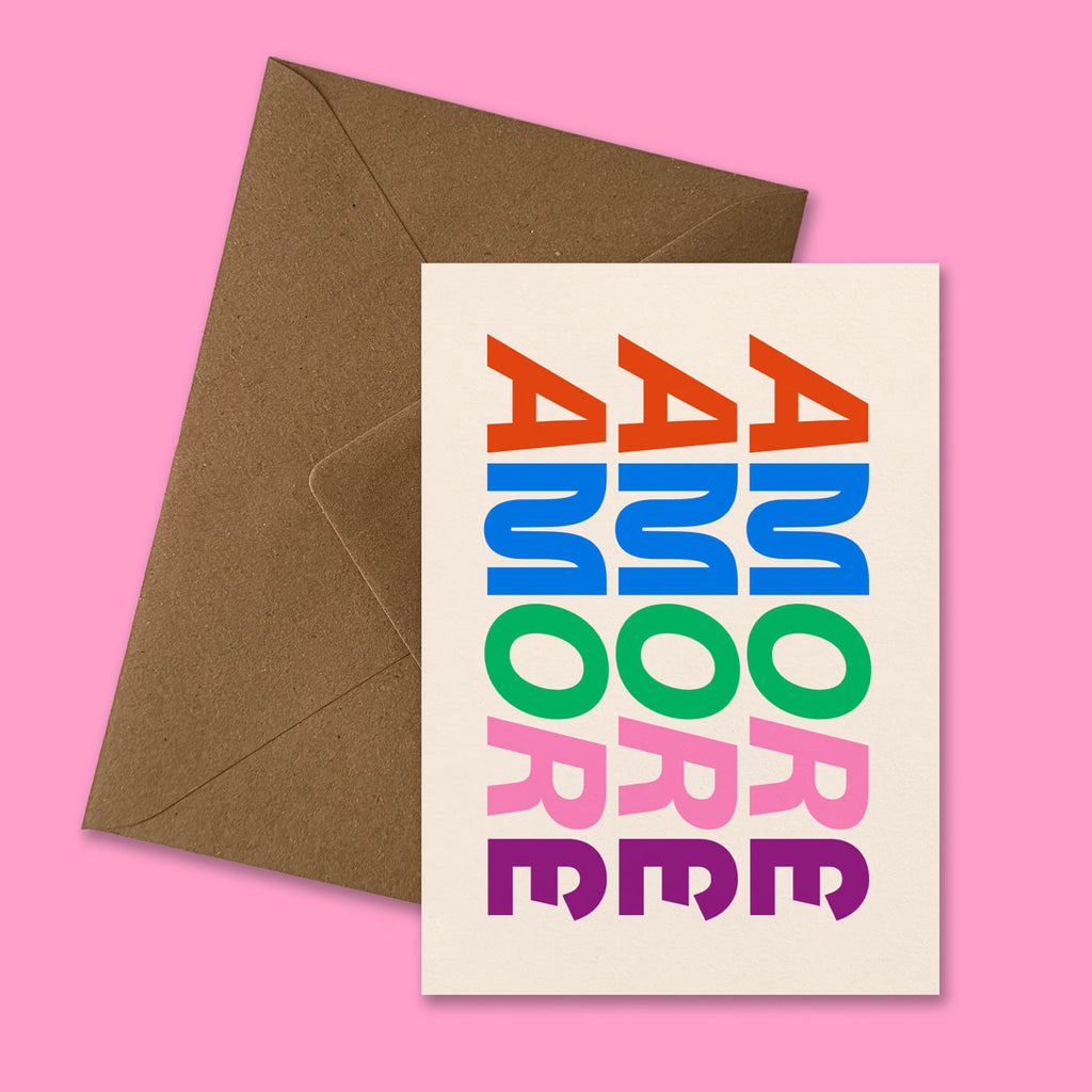 Moderne Karte ‚AMORE‘ mit buntem Schriftzug präsentiert mit braunem recyceltem Kraftpapier-Umschlag produziert in Deutschland.
