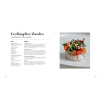 Gedämpfter Zander – Sonnenblumenkerne | Rote Bete | Sommerblüten: „Zart gegarter Zander mit Rote-Bete-Streifen, Sonnenblumenkern-Mayonnaise und essbaren Blüten, kunstvoll arrangiert auf einem hellen Teller.“