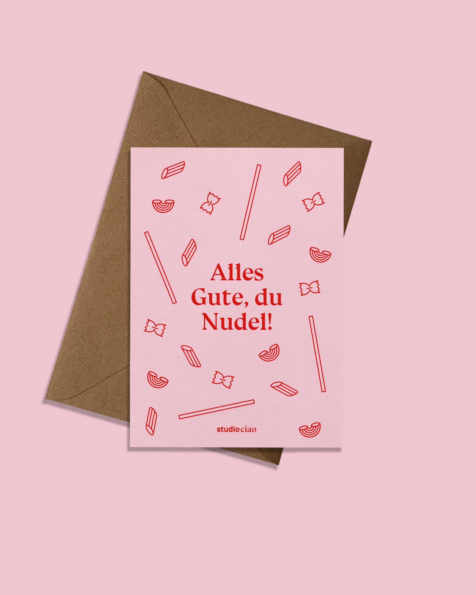 Geburtstagskarte „Alles Gute, du Nudel!“ von studio ciao mit rosa Vorderseite, roten Pasta Illustrationen und braunem nachhaltigem Briefumschlag, moderne humorvolle Grußkarte zum Geburtstag.