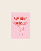 Geburtstagskarte mit rosa Hintergrund und roter Illustration einer Hand mit Pizza und dem Schriftzug „Hoch sollst du leben!“, humorvolle Pizza Geburtstagskarte für Kinder und Erwachsene von studio ciao.