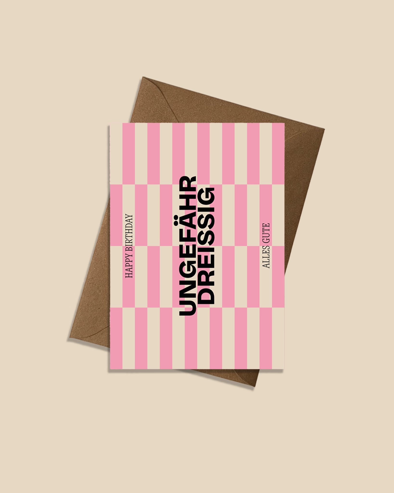 Moderne Geburtstagskarte ‚Ungefähr Dreissig‘ mit grafischem Streifenmuster in Pink und Beige, schwarzer Typografie und Aufschrift ‚Happy Birthday‘ und ‚Alles Gute‘, präsentiert mit braunem recyceltem Kraftpapier-Umschlag produziert in Deutschland