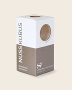 Verpackung des Nussknackers NUSSKUBUS von Siebensachen mit Sichtfenster, das das Buchenholz zeigt. Hochwertige Box in Weiß und Braun mit modernem Design und klarer Typografie.
