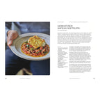 Gebratener Safran-Seeteufel mit Augenbohnen: Ein angerichteter Teller mit einem gebratenen Stück Seeteufel auf einem würzigen Augenbohnen-Tomatenragout, garniert mit frischen Kräutern. Der Teller wird von einer Hand gehalten.