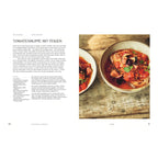 Tomatensuppe mit Feigen: Zwei Schalen mit kräftig roter Tomatensuppe, belegt mit frischen Feigenstücken, Oregano und geröstetem Brot. Die Schalen stehen auf einem rustikalen Holztisch.