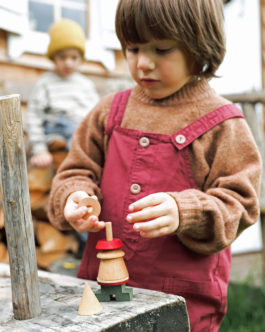 Ein Kind spielt mit einer Holzsteckfigur von Wooden Story, Montessori Holzspielzeug aus FSC zertifiziertem Holz
