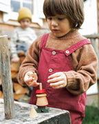 Ein Kind spielt mit einer Holzsteckfigur von Wooden Story, Montessori Holzspielzeug aus FSC zertifiziertem Holz