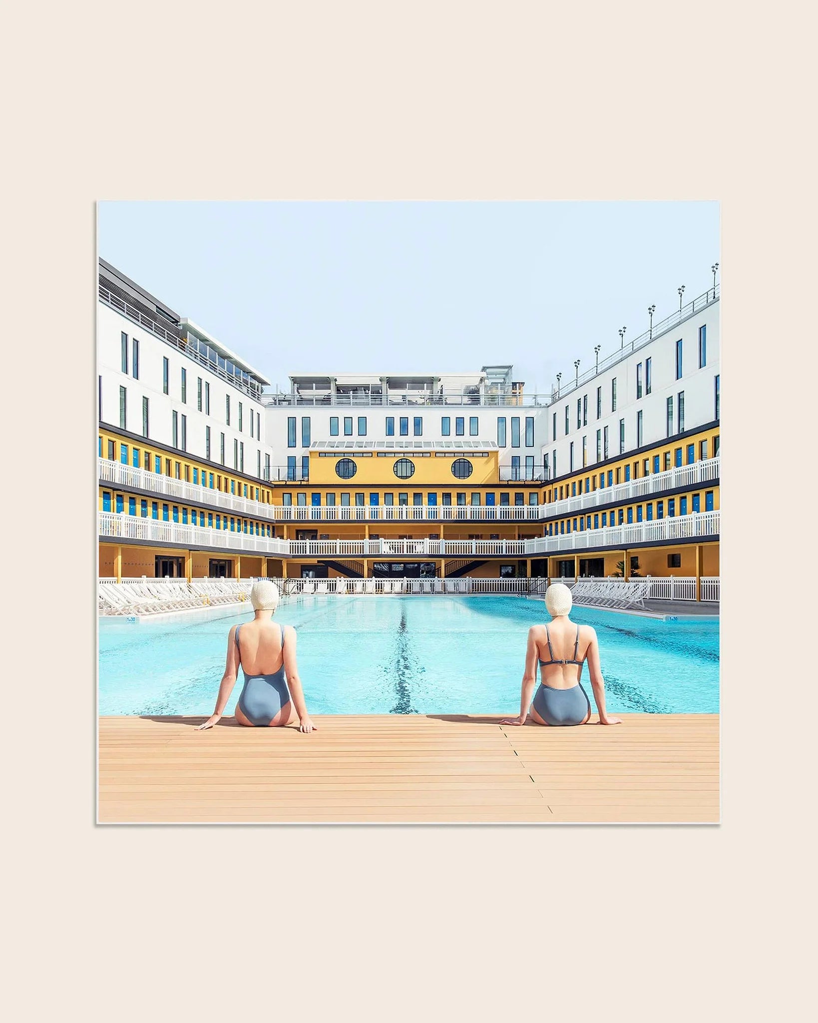Fotokunstwerk Summer Swim at Molitor von Soo Burnell aus der Serie Into the Blue, zeigt zwei Frauen in Badeanzügen am Pool des legendären Hôtel Molitor in Paris, inspiriert von der Ästhetik Wes Andersons.