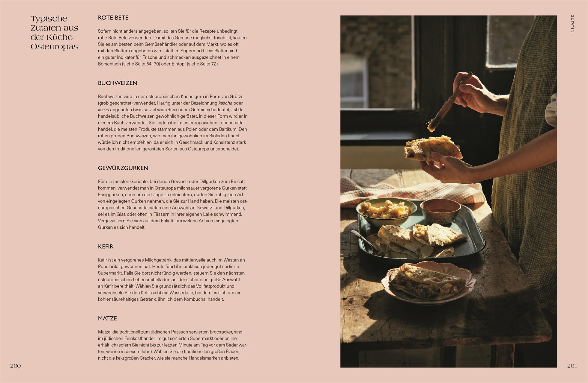Kapitel „Typische Zutaten aus der Küche Osteuropas“. Links Beschreibungen von Roter Bete, Buchweizen, Gewürzgurken, Kefir und Matze, rechts Hände beim Bestreichen von Brotfladen mit Butter, dazu Schalen mit Beilagen.