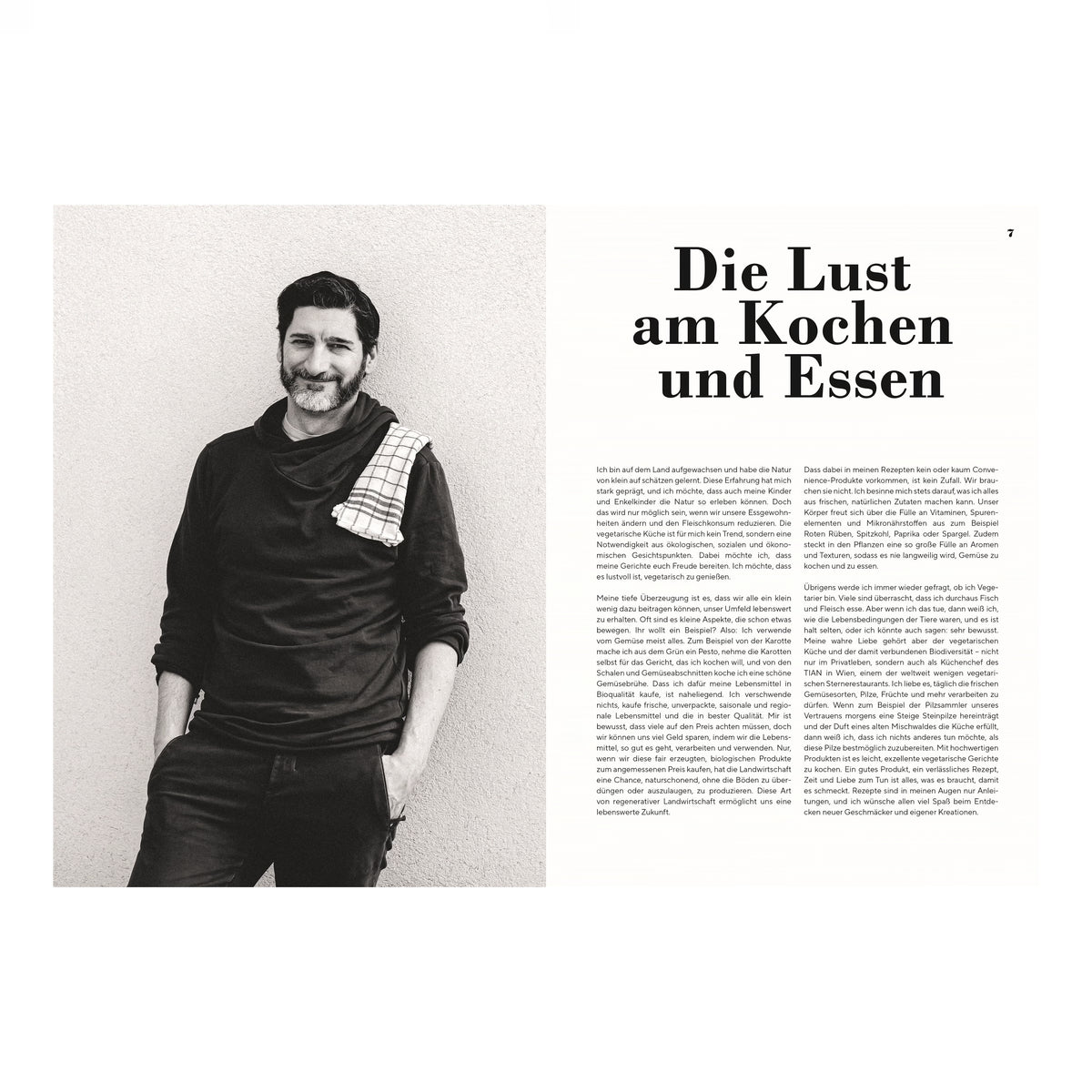 Portrait Paul Ivić: Schwarz-weißes Portrait des Kochs Paul Ivić mit Bart, lächelnd, in dunkler Kleidung und kariertem Küchentuch über der Schulter, vor hellem Hintergrund.