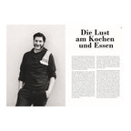 Portrait Paul Ivić: Schwarz-weißes Portrait des Kochs Paul Ivić mit Bart, lächelnd, in dunkler Kleidung und kariertem Küchentuch über der Schulter, vor hellem Hintergrund.