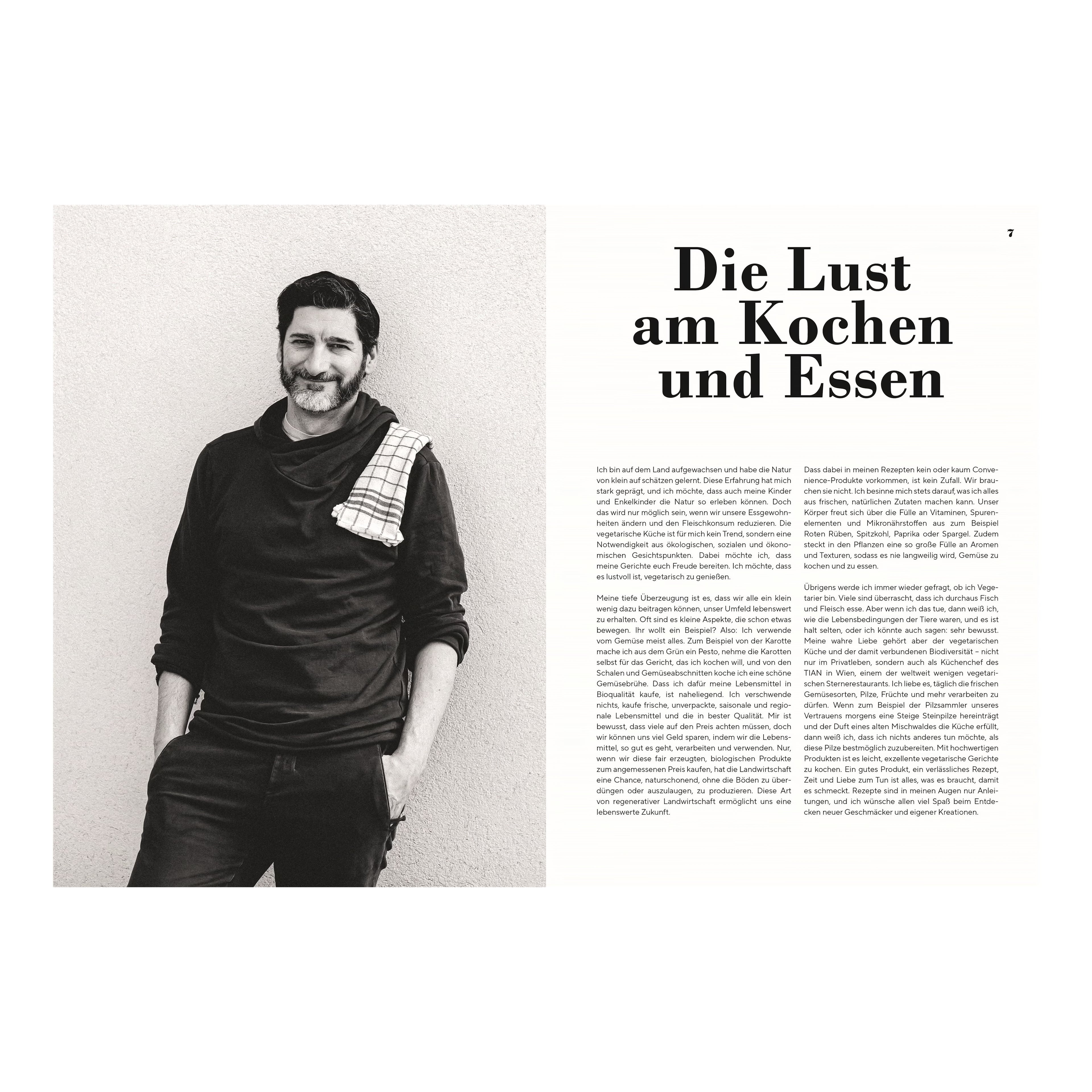 Portrait Paul Ivić: Schwarz-weißes Portrait des Kochs Paul Ivić mit Bart, lächelnd, in dunkler Kleidung und kariertem Küchentuch über der Schulter, vor hellem Hintergrund.