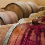 Close-up of barrique barrels with deep red wine stains on oak wood. Symbolic image for the Barrique ballpoint pen by e+m made from genuine wine barrel wood.