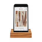 Phone holder Phone Board by e+m made of oak wood with a smartphone placed in the holder. Elegant wooden stand for desk kitchen or living room handcrafted in Germany.