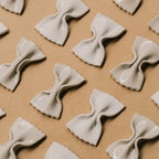 Mehrere handgefertigte LA FARFALLE Messerablagen aus Keramik von OEUVRES SENSIBLES auf braunem Untergrund. Inspiriert von italienischer Farfalle-Pasta, glänzende Glasur in Farbe Grès Shinny, gefertigt in Marseille. Stilvolle Tischaccessoires aus Frankreich. Bild © Maxime Verret