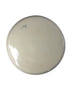 Underside of the handcrafted Traços plate by Mica Barbot from Nice with artist’s signature. The fine glaze and slight irregularities of the surface emphasize the authentic handcrafted character of each individual piece.