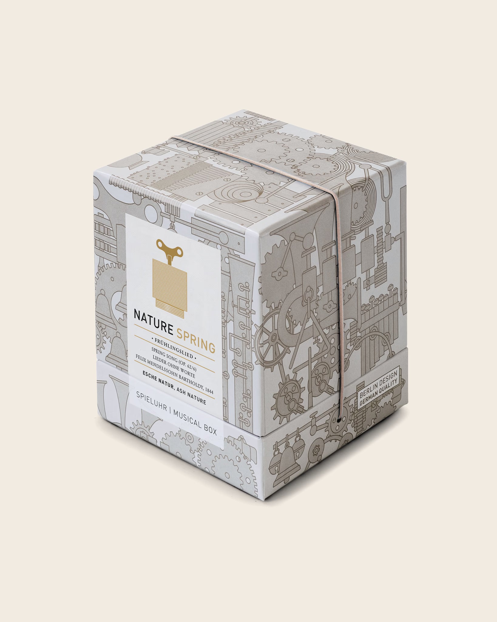Geschenkverpackung der Spieluhr ‚Nature Spring‘ von Siebensachen, dekorative Schachtel mit technischen Linienzeichnungen und Produktetikett in Beige und Gold.