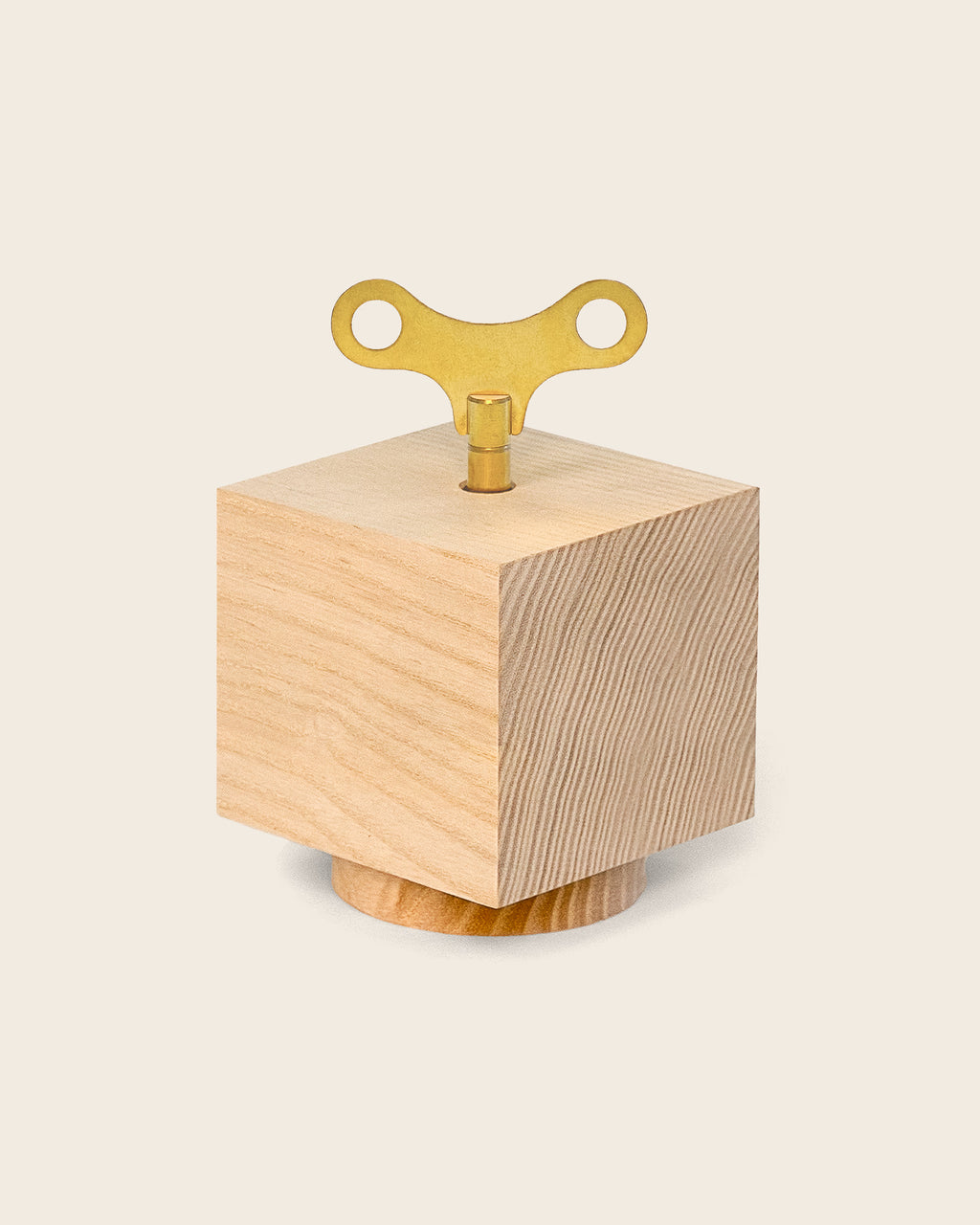 Spieluhr ‚Nature Spring‘ von Siebensachen aus naturbelassenem Eschenholz, kubisches Design mit goldenem Aufziehschlüssel.