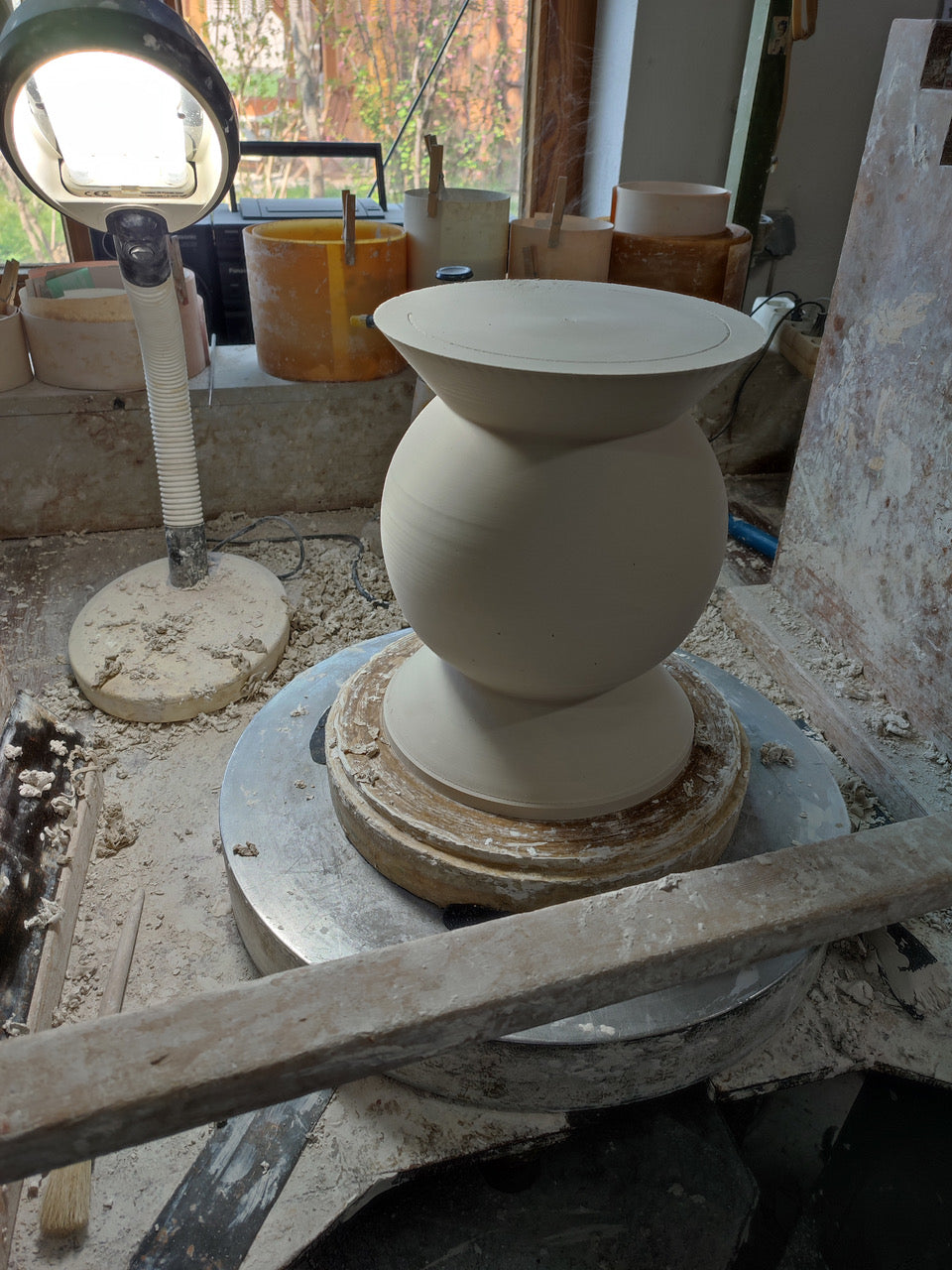 Keramikvase von NIEVEN in der Entstehung auf der Töpferscheibe. Das Atelier zeigt handwerkliche Präzision, natürliche Materialien und liebevolle Detailarbeit.