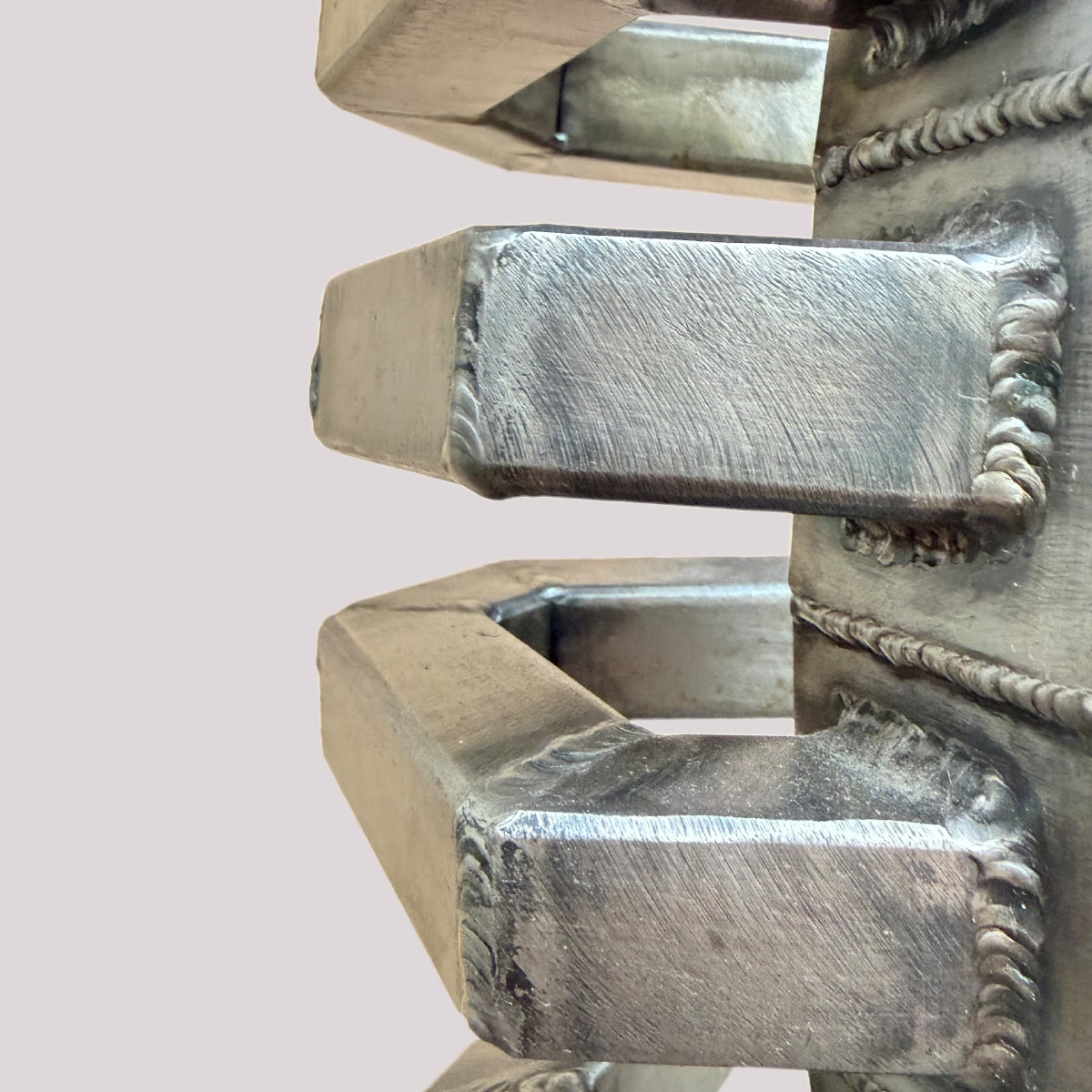 Detailaufnahme der Stahlskulptur ‚Objekt H‘ von Till Kräusel mit geschweißten Stahlarmen, sichtbaren Schweißnähten und gebürsteter Metalloberfläche