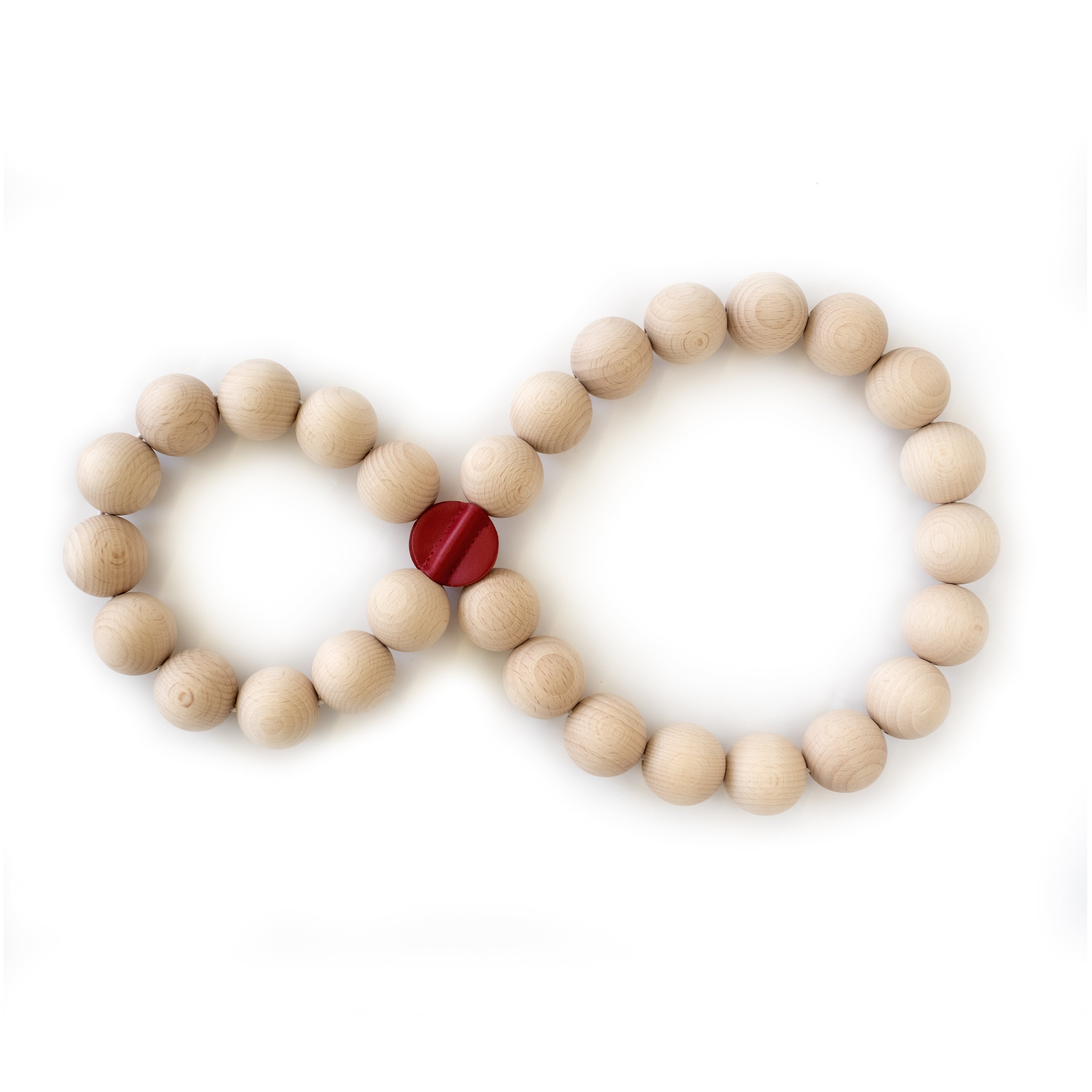 Topfuntersetzer PERLE von Siebensachen in Form einer Acht gelegt. Gefertigt aus naturbelassenen Buchenholzkugeln mit roten Lederpatches. Flexibel und dekorativ für mehrere Töpfe.