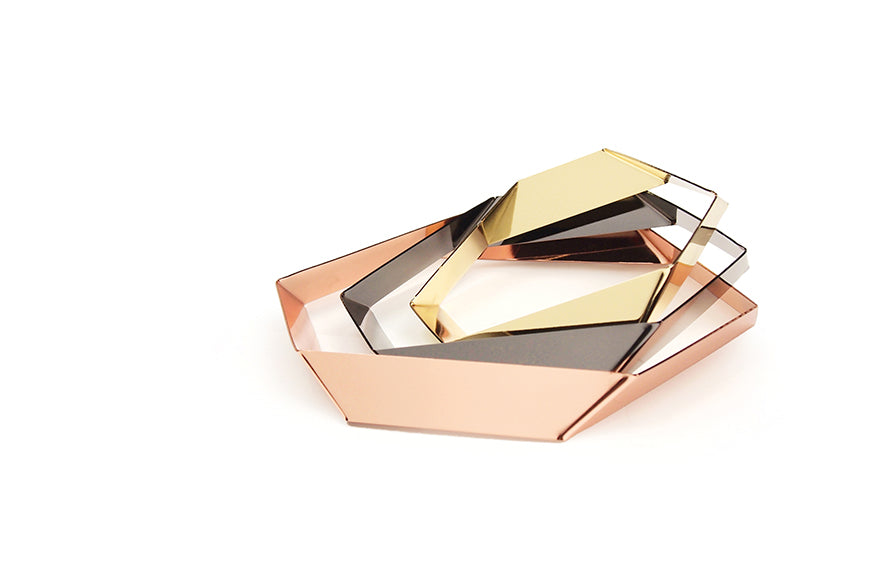 Design-Untersetzer-Set HEXAGON von Siebensachen aus polierten Metallbändern. Glänzt in den Farben Messing, Kupfer und Gold. Die prismatischen Elemente lassen sich zu einer dekorativen, floralen Tischskulptur arrangieren. Teil der A+H Foreign Affairs Reihe.