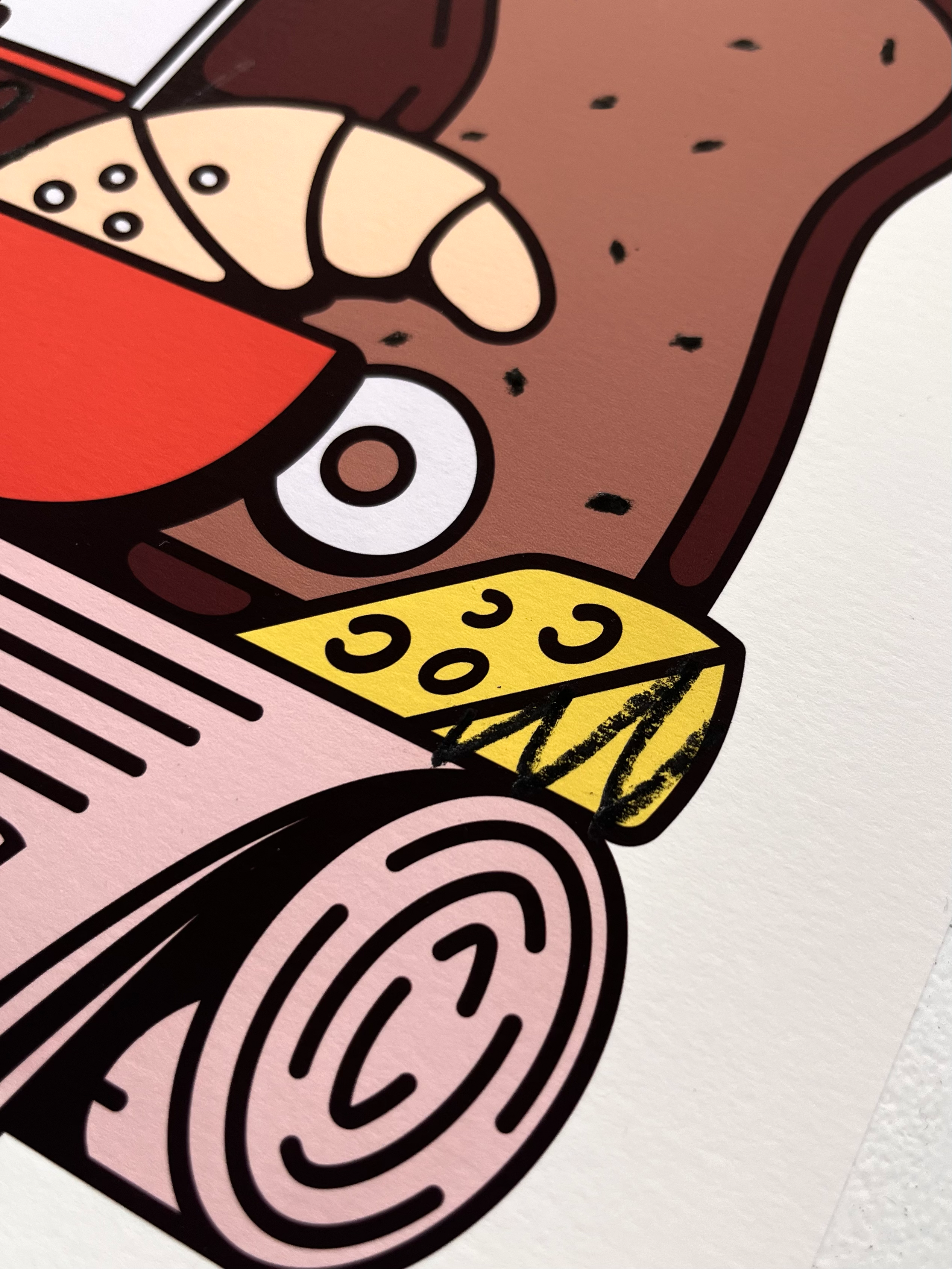 Detail view of the Fine Art Print Wiener Standard Frühstück by RadandYellow shows the precise printing and vibrant colors of the illustration with cheese croissant bread and newspaper. The high quality art print stands out with clean lines rich color application and fine texture on Fotospeed Art Smooth paper.