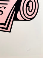 Detail of the Fine Art Print Wiener Standard Frühstück by RadandYellow shows the lower part of the illustration with a pink newspaper and the artist’s signature. The high quality art print on textured paper highlights the clear line work and precise color composition of the artwork.